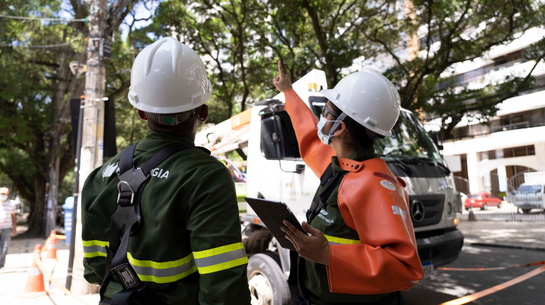 Foto de dois eletricistas trabalhando na rua