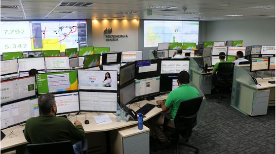 Foto de centro de operações com funcionários trabalhando em diversos monitores que aparecem à frente deles