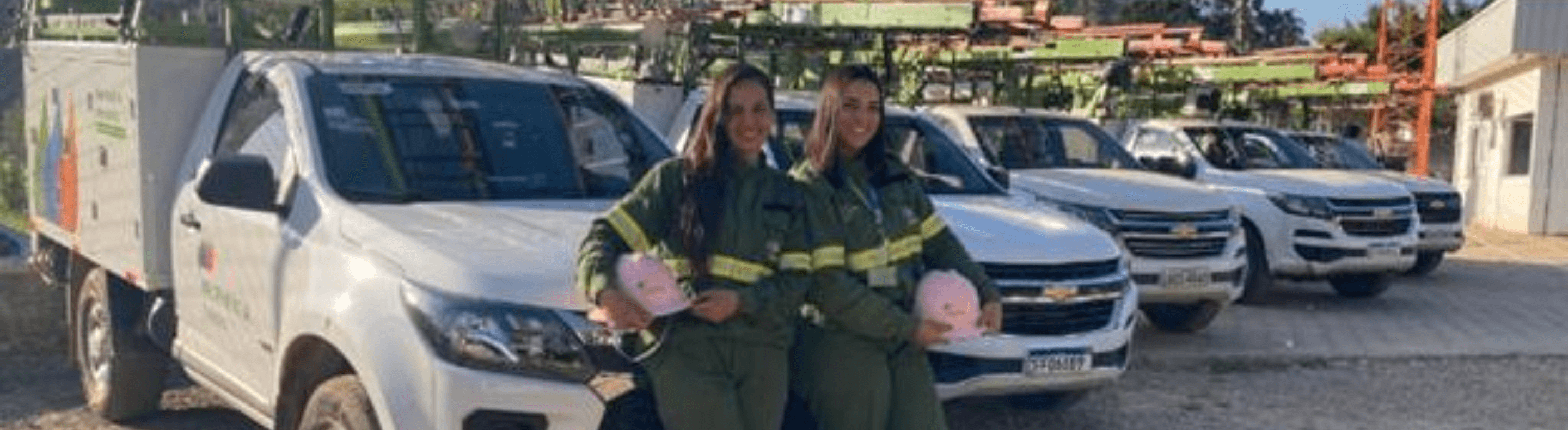 Eletricistas mulheres da Neoenergia Elektro posando para foto em frente a caminhões da distribuidora