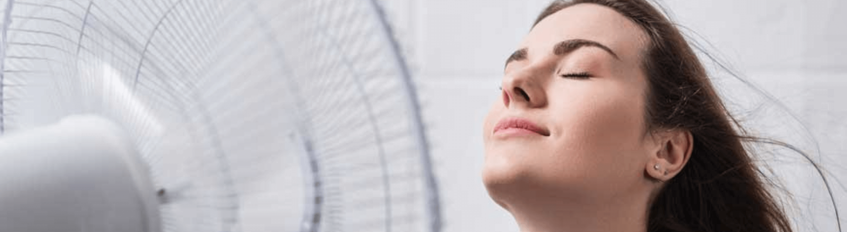 Mulher em frente ao ventilador aproveitando o vento