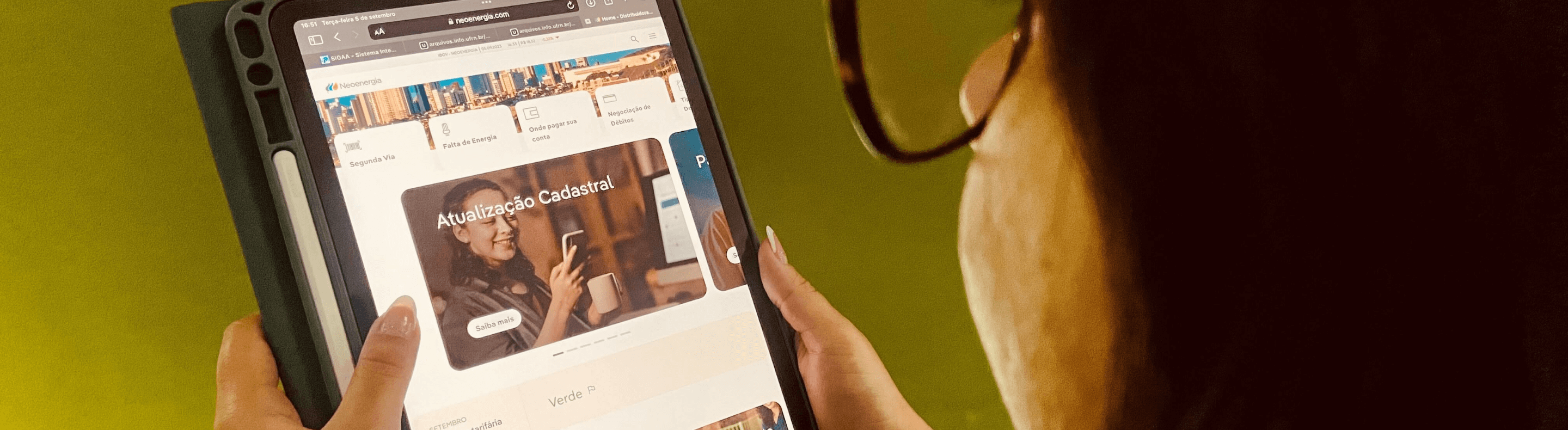 Cliente da Neoenergia Elektro com um dispositivo eletrônico aberto na página home do site da Neoenergia
