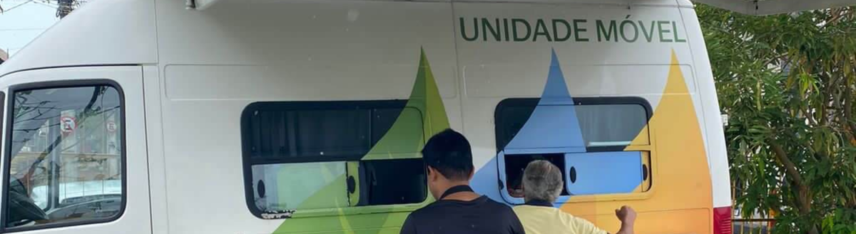 Van da Unidade Móvel da Neoenergia atendendo dois clientes.