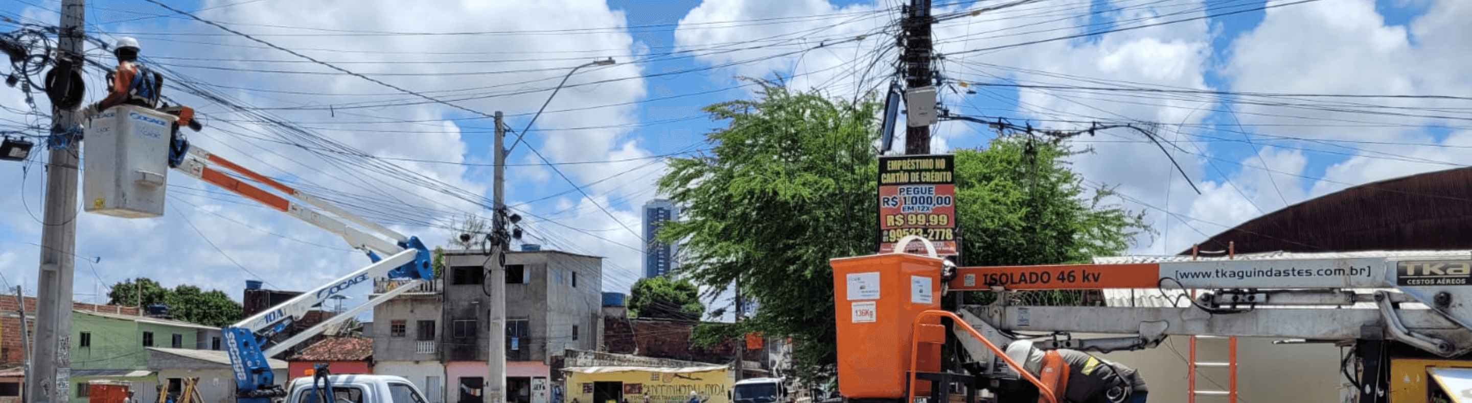 Dois caminhões da Neoenergia com profissionais atuando em postes e fiação