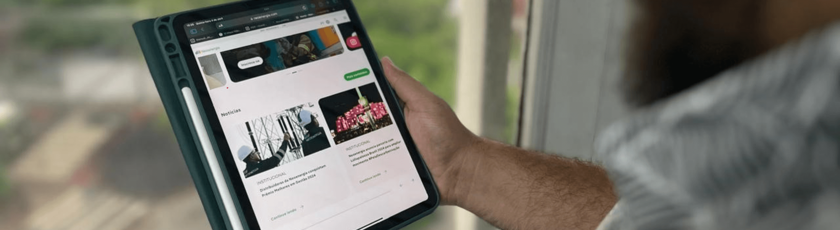 Homem com a homepage do site da Neoenergia aberto em seu tablet