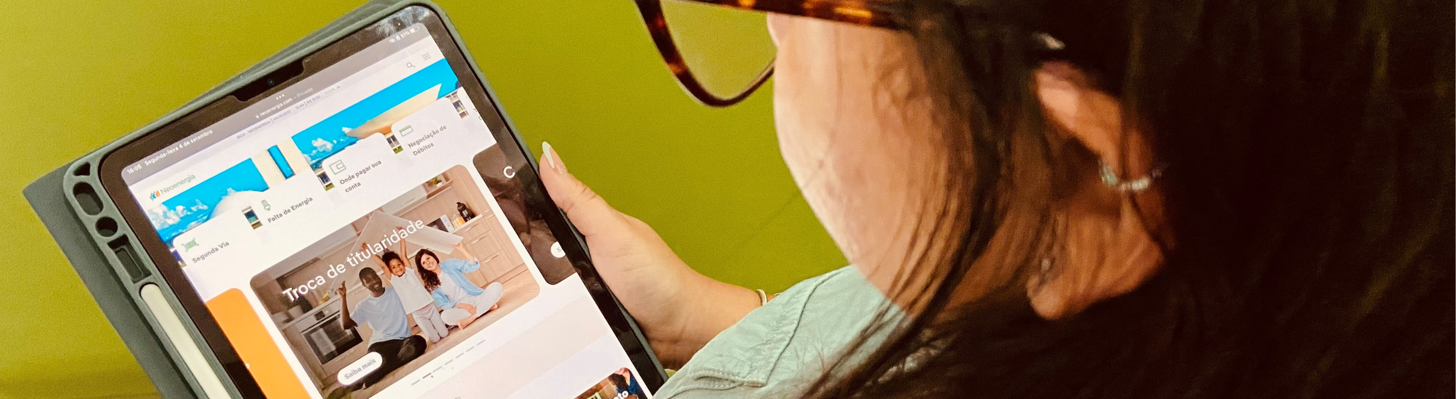 Imagems mostra mulher acessando serviços digitais da Neoenergia Brasília através de um tablet