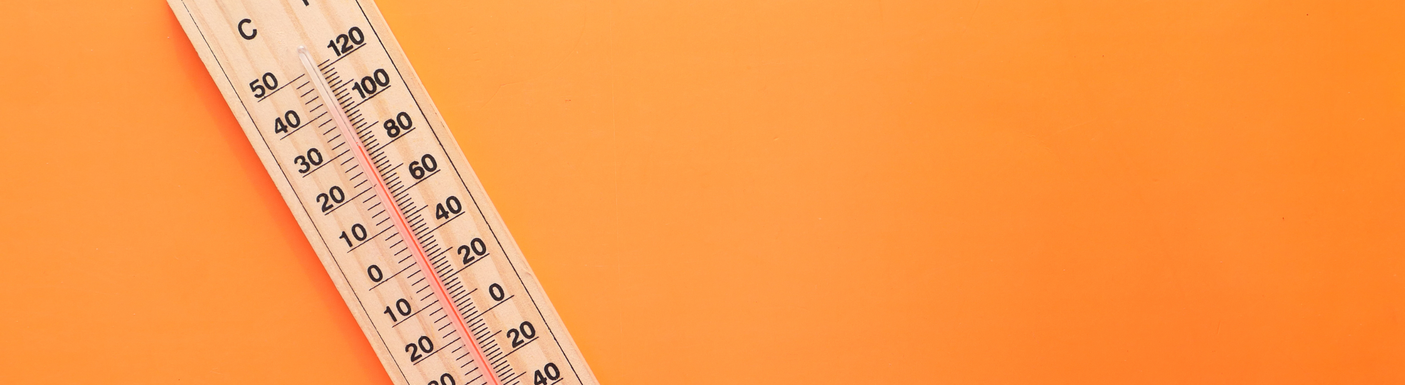 Termômetro marcando altas temperaturas em um fundo laranja