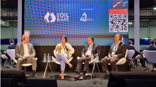 Foto de Laura Porto e executivos em palco durante painel na ROG