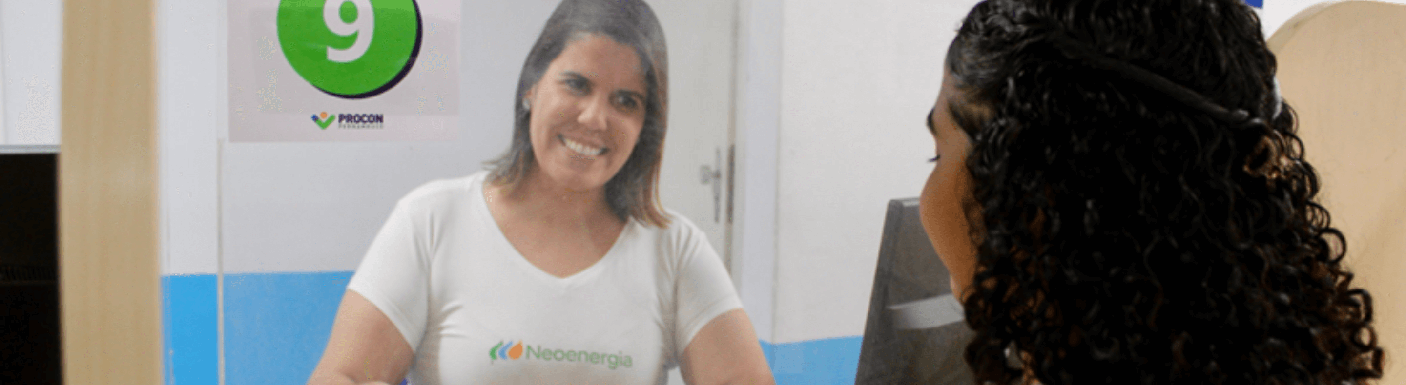 Colaboradora da Neoenergia Pernambuco com uma cliente no Procon