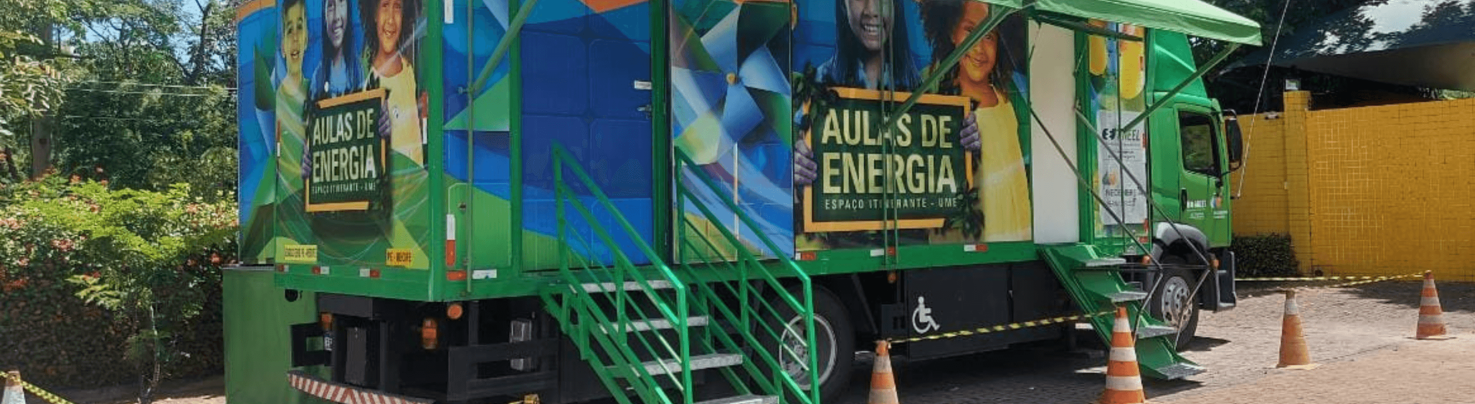 Caminhão do Projeto Aulas de Energia da Neoenergia Elektro estacionado com as cores predominantes verde e azul